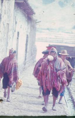 [Camponeses peruanos caminham em rua de vila]